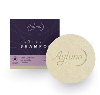 Ayluna Festes Shampoo bar shown next to its dark purple and lavender packaging box on a clean white background.