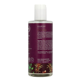 A bottle of Baseline Naturawerk Shampoo Sensitiv on a white background, featuring a deep purple label with white text and botanical illustrations at the bottom.